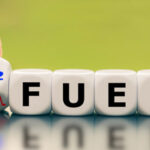 Hand turns a dice and changes the expression "fossil fuel" to "H